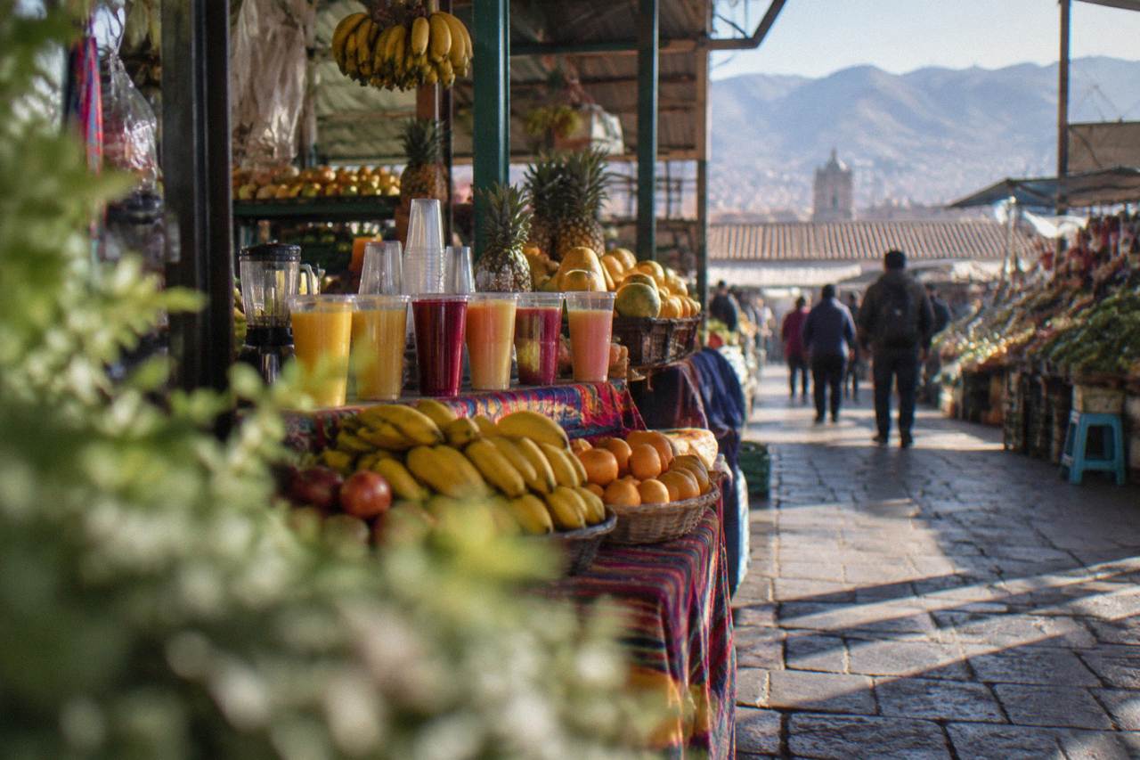 Fresh fruit juices and produce displayed on a market stall in Cusco, Peru