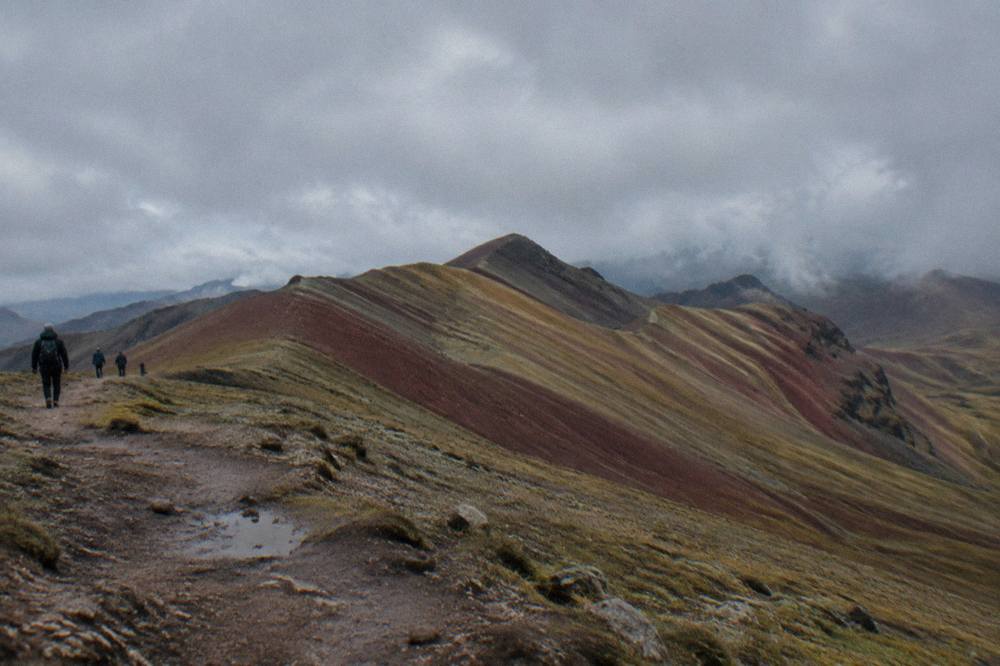 Striped red and ochre mountain slopes under a wide sky in the Peruvian Andes
