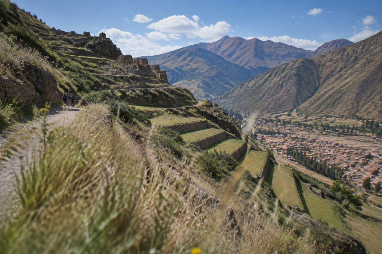 Terraced Andean hillsides above a valley town with mountains in the distance