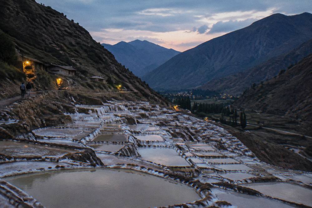 Salt evaporation pans terraced into a hillside under a wide sky
