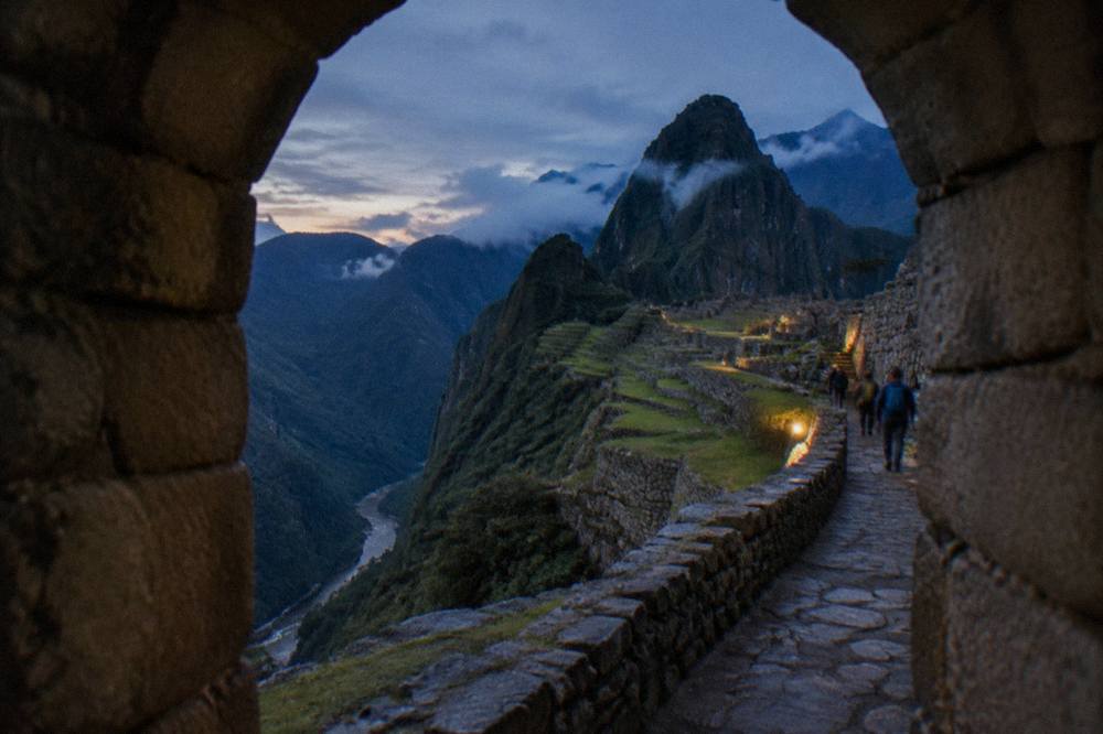 Terraced Inca stonework on a mountainside above a river canyon on a walking route toward Machu Picchu