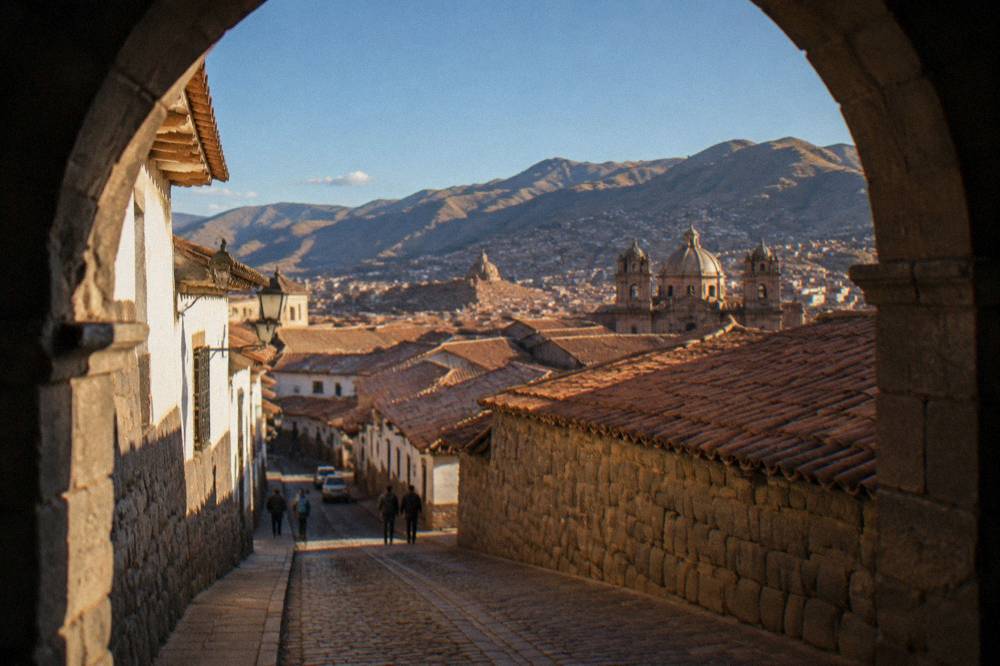 Terracotta roofs of a high Andean city under a clear blue sky with distant hills