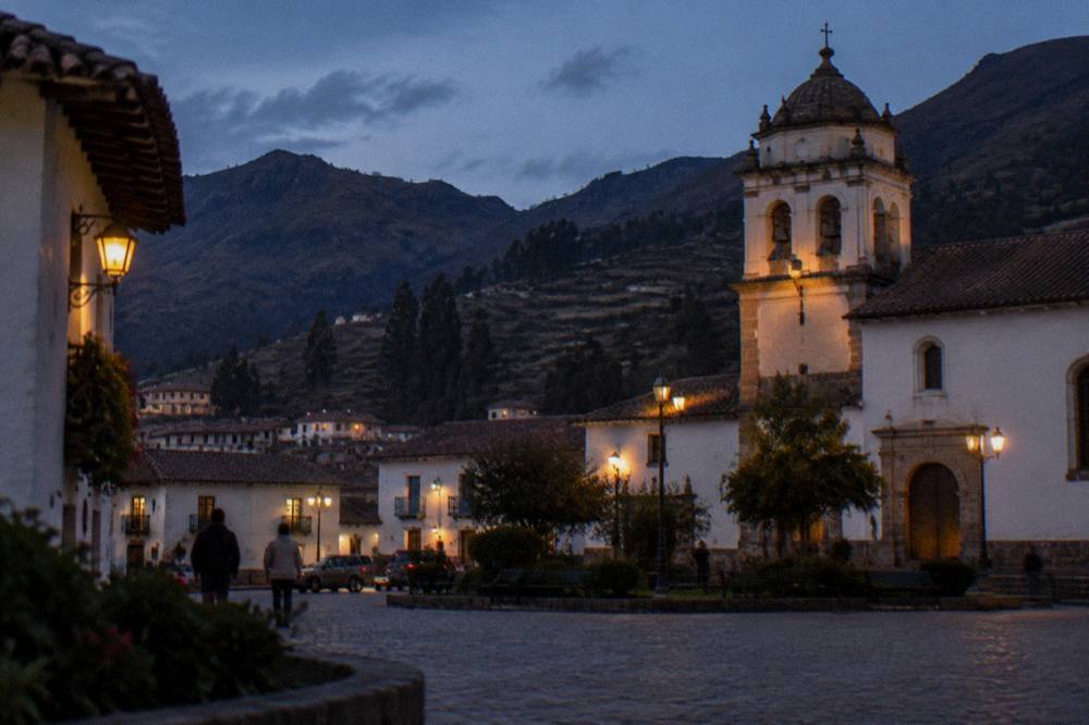 Whitewashed houses and a church tower in a small Andean town square