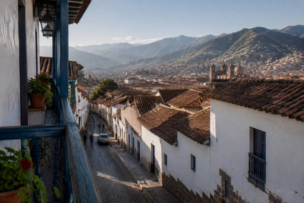 A colonial balcony overlooking steep lanes and distant Andean hills