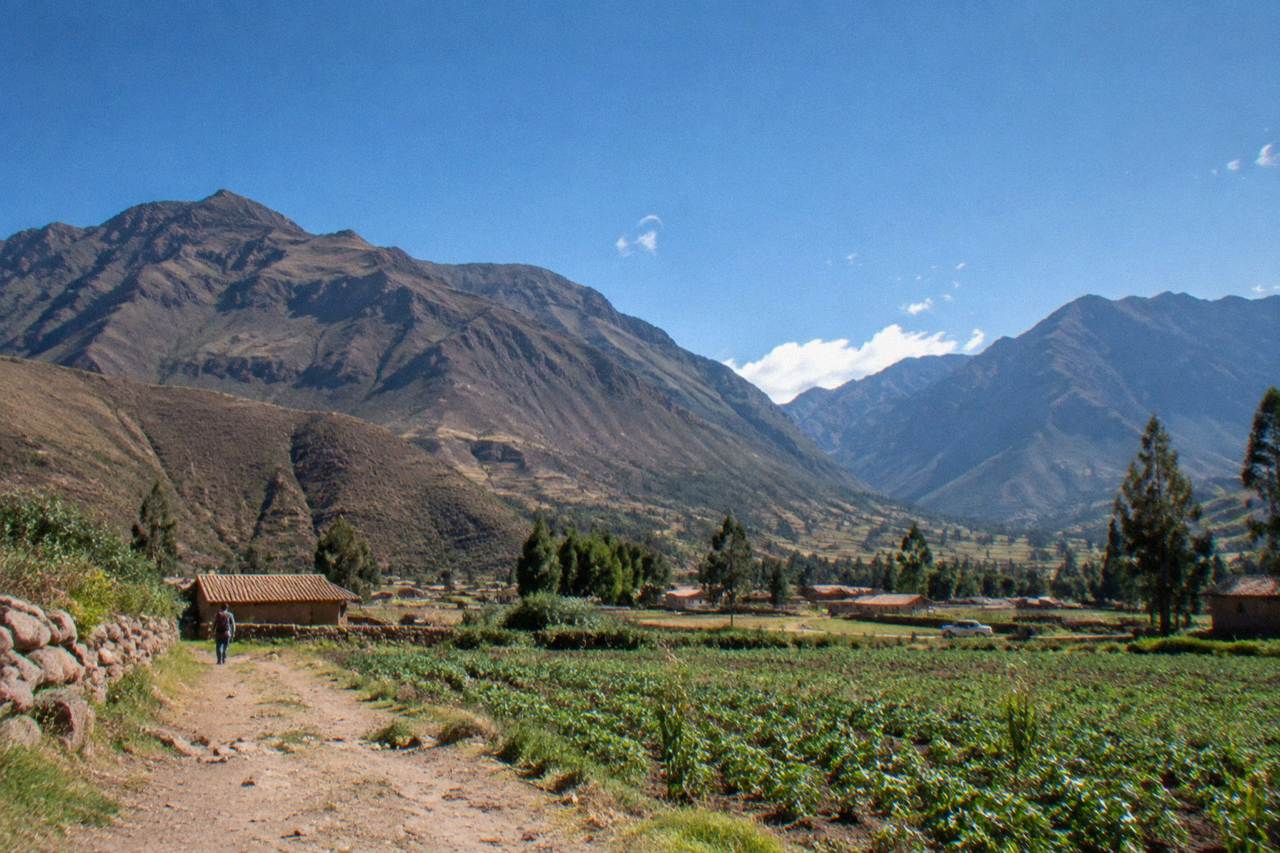 A quiet Andean valley town with fields and mountains under a wide sky
