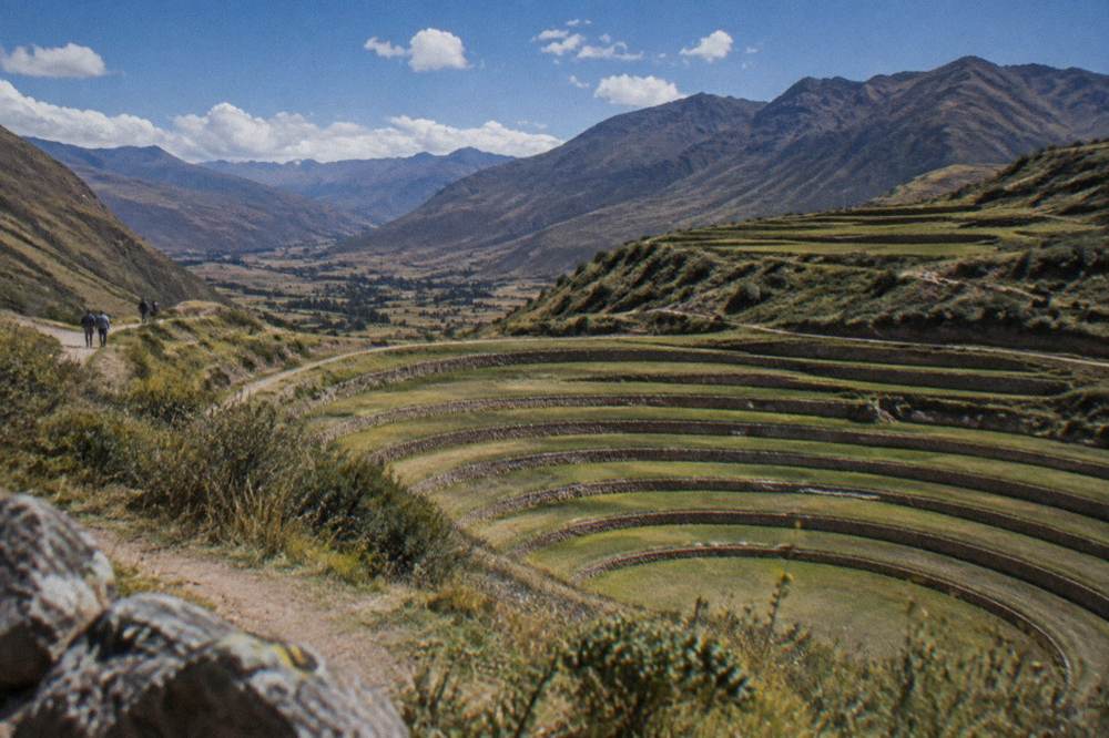 Concentric farming terraces sunk into a high plateau with the valley beyond