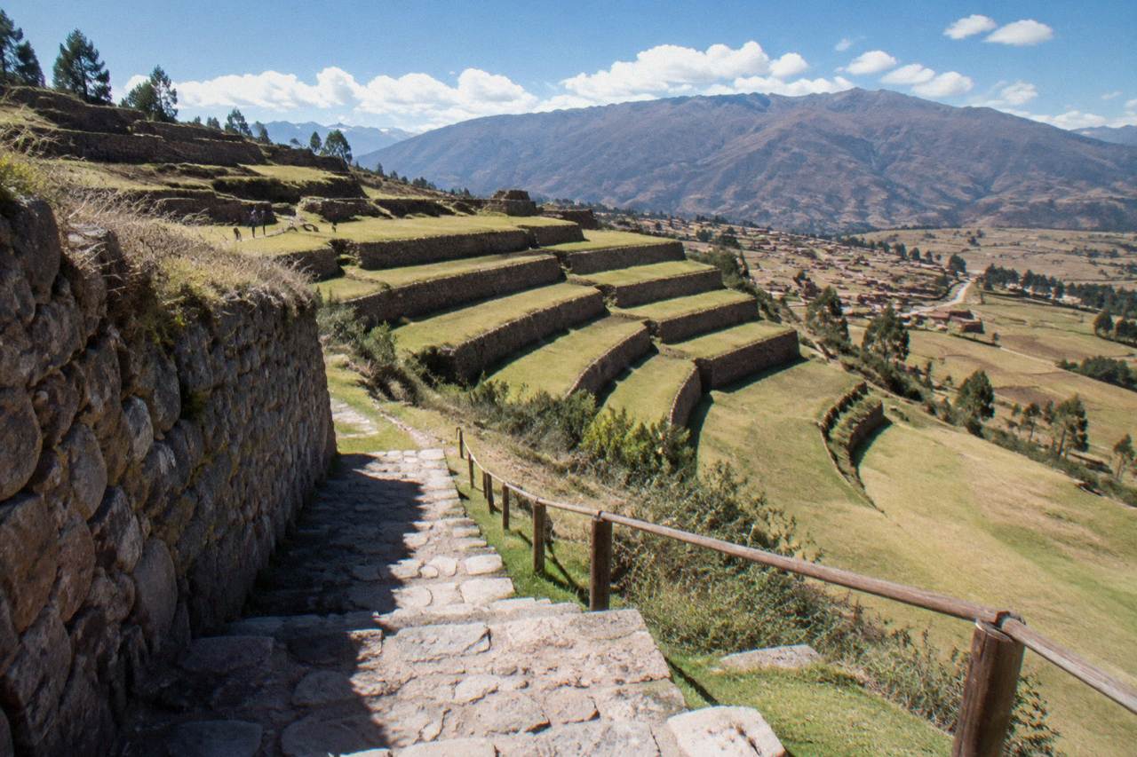 Inca farming terraces stepping down a hillside at Chinchero under a wide Andean sky