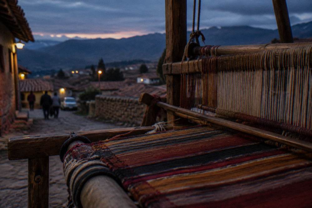A wooden loom with threads of naturally dyed wool stretched tight