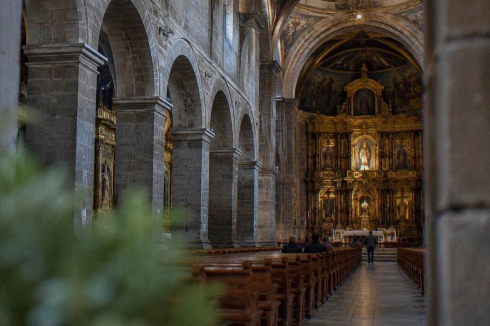 The stone arches and columns of the Cathedral nave leading toward the main altar