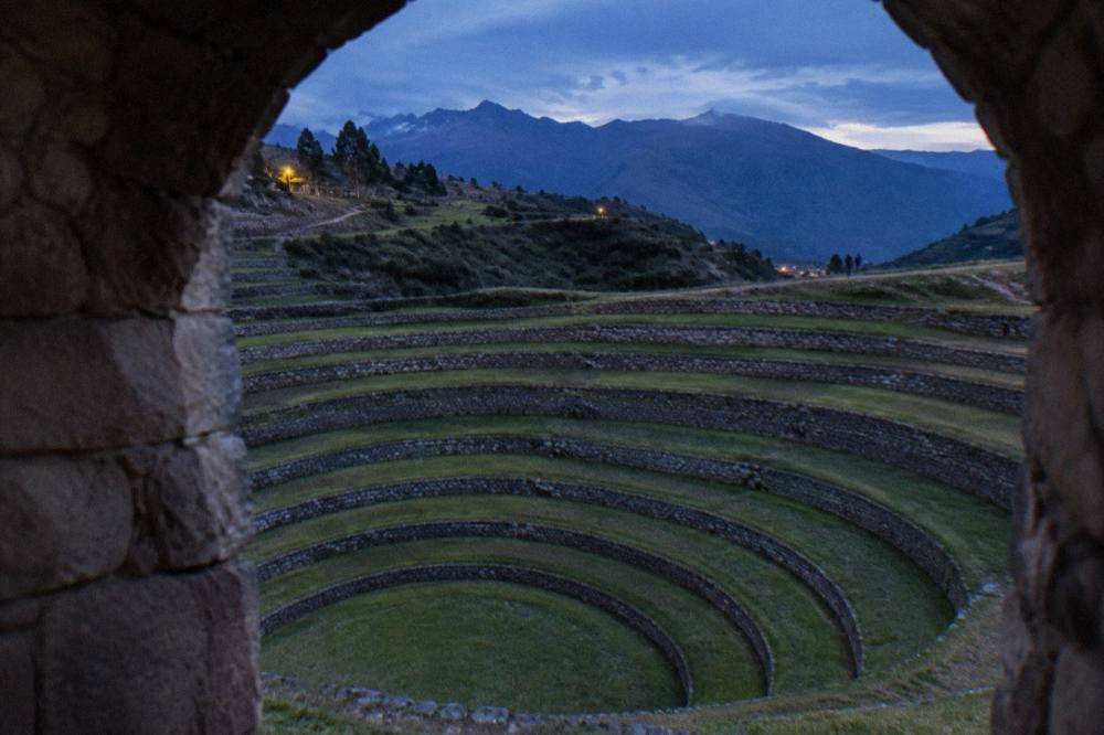 A close view of stone retaining walls forming deep terrace rings at Moray with grass on every step