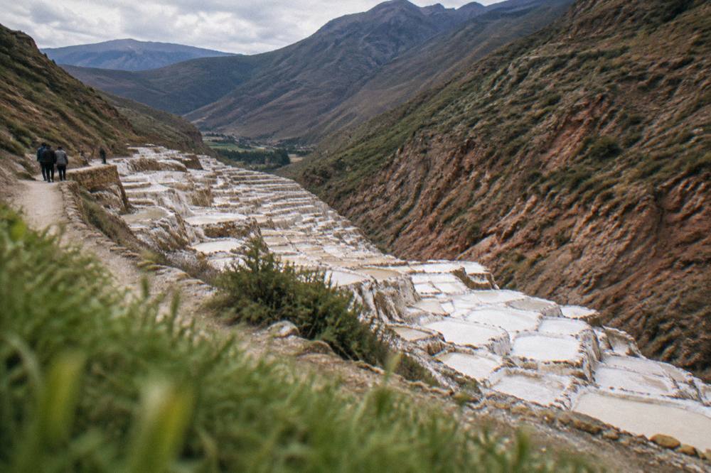 Salt evaporation pans terraced down a hillside near Maras with white crusts shining in daylight