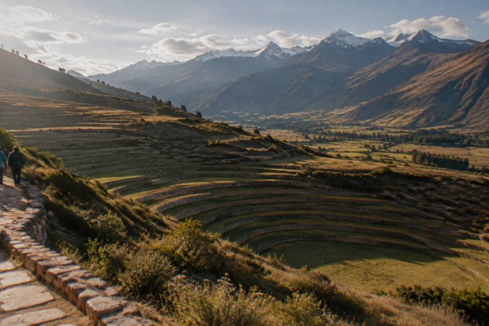 A wide view across the Sacred Valley with terraced fields and distant snow peaks