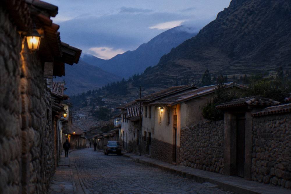A quiet valley street in early morning light with hillsides rising behind the rooftops