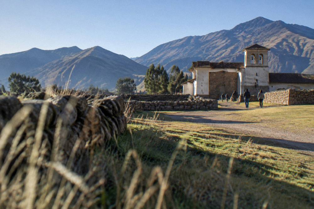 Low ancient walls and open ground under a clear sky in southern Peru