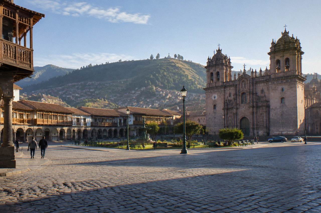 The main square of Cusco with colonial arcades, cathedral towers and the Andean hills behind