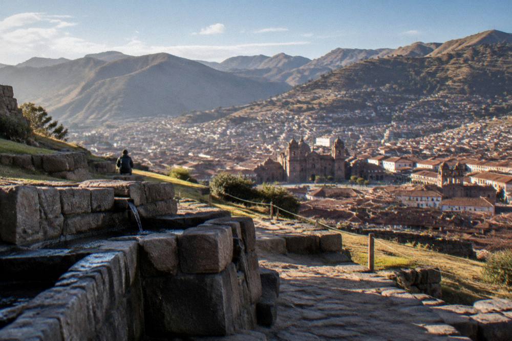 A wide view over Cusco's rooftops and surrounding hills seen from a high stone lookout