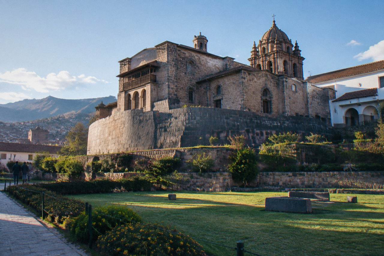 The Inca stone walls of Qorikancha in Cusco with the tower of the church of Santo Domingo rising above them