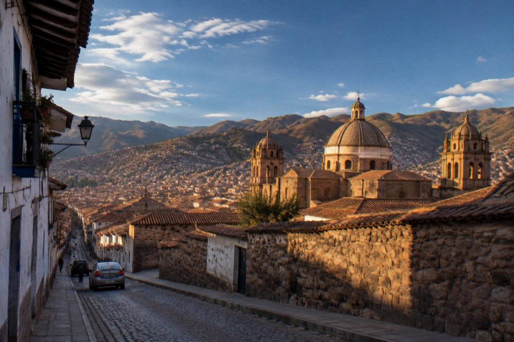 Golden late afternoon light on the historic rooftops and church domes of Cusco