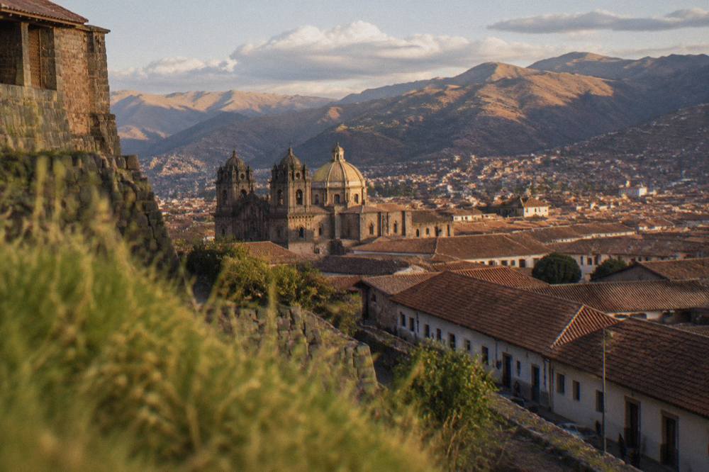 A rooftop view over the historic centre of Cusco with Andean mountains behind