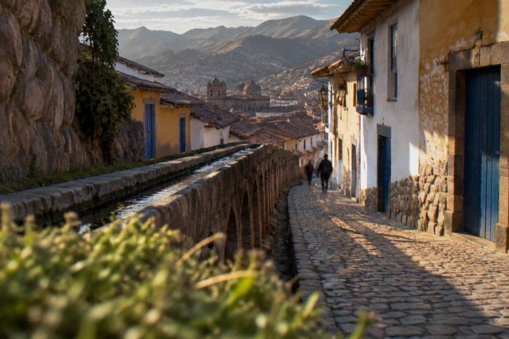 A narrow lane of white and ochre houses with blue doors climbing the San Blas hillside