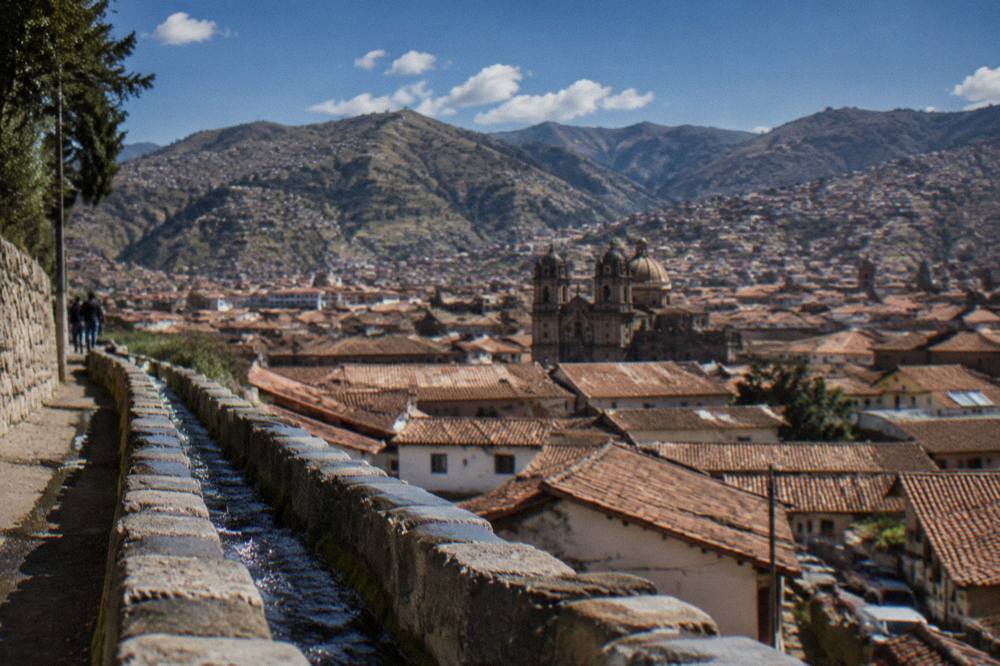A view over Cusco's red tiled roofs with the surrounding Andean hills behind