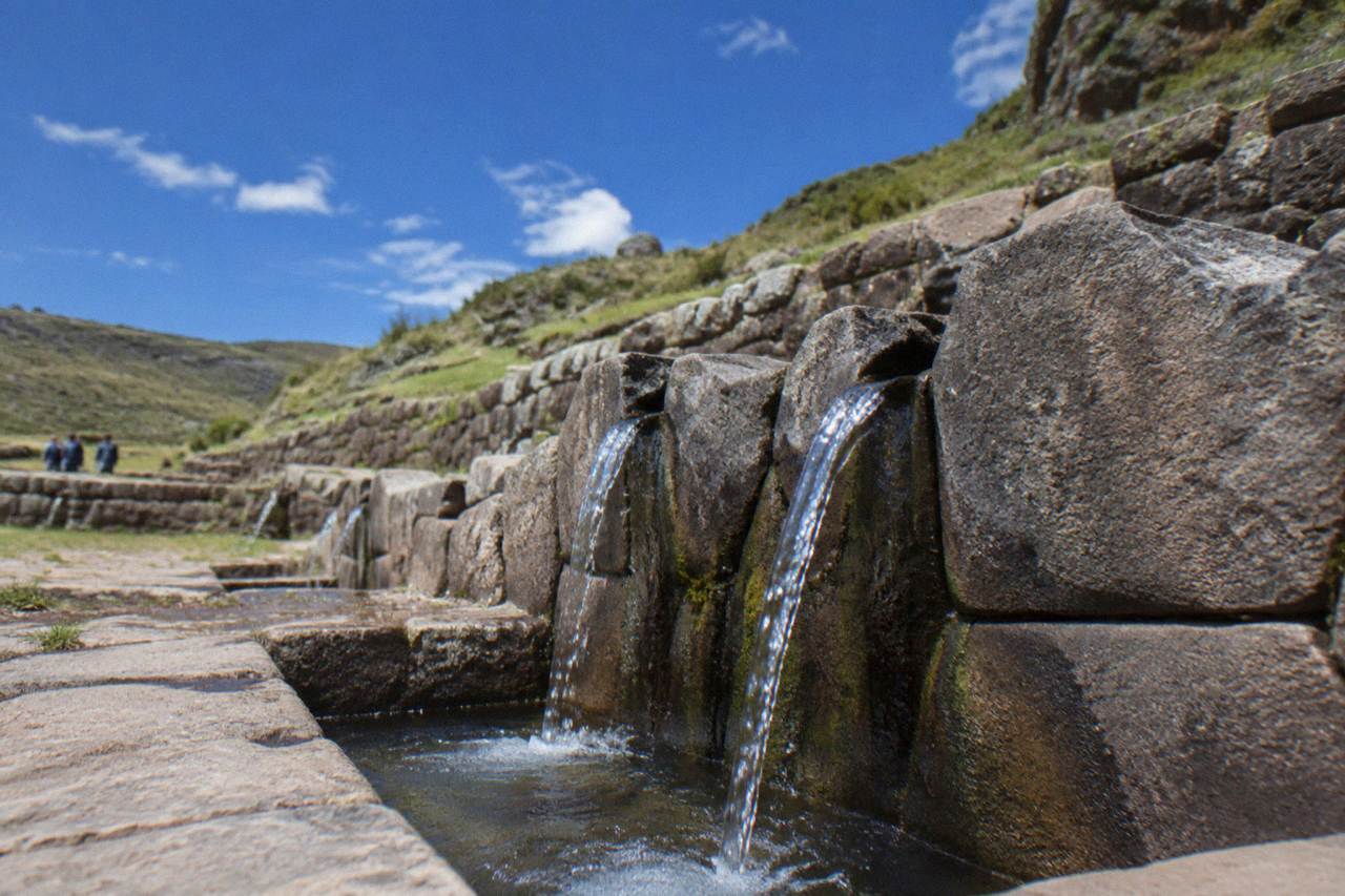 An Inca stone water channel feeding a small fountain at Tambomachay near Cusco