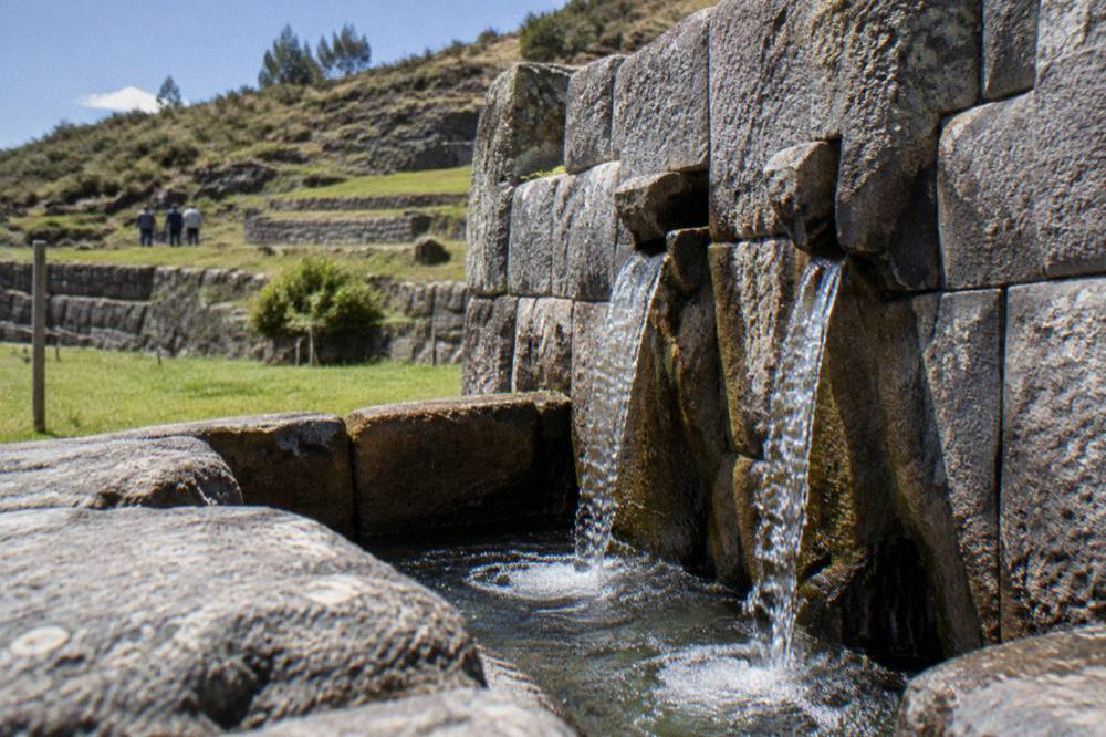 A stone fountain niche with flowing spring water at Tambomachay near Cusco