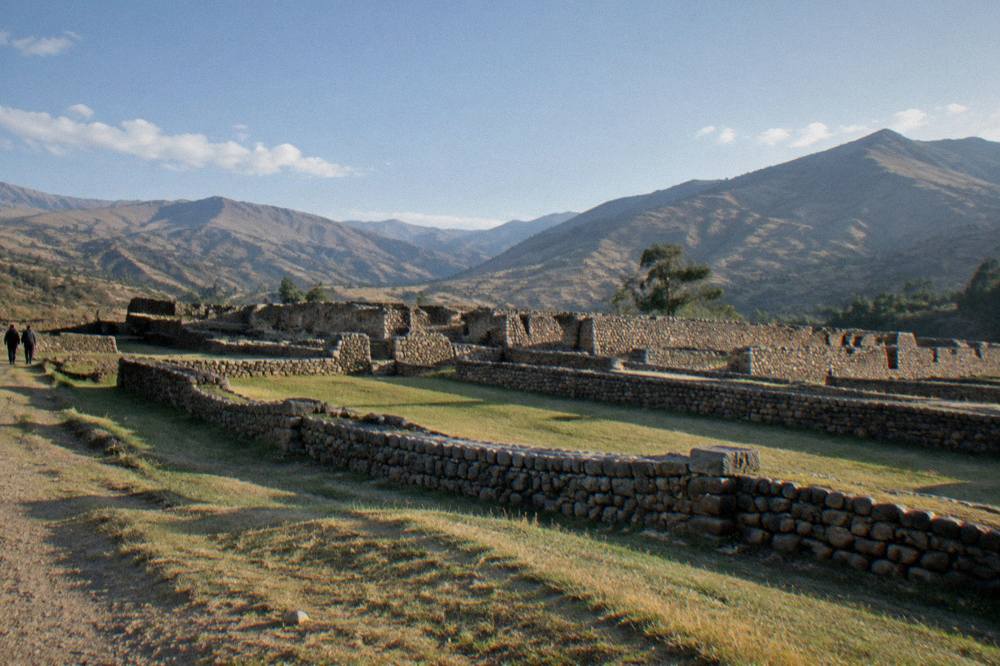 Long low stone walls of the Pikillacta compound under a wide sky in the South Valley