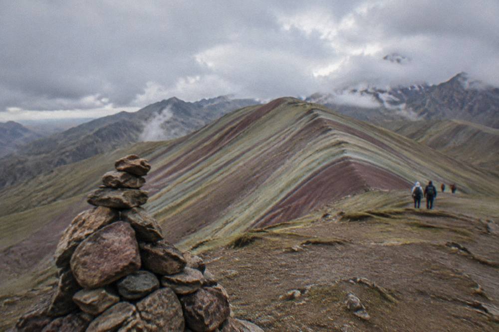 Morning light on a striped ridge with a stone cairn in the foreground