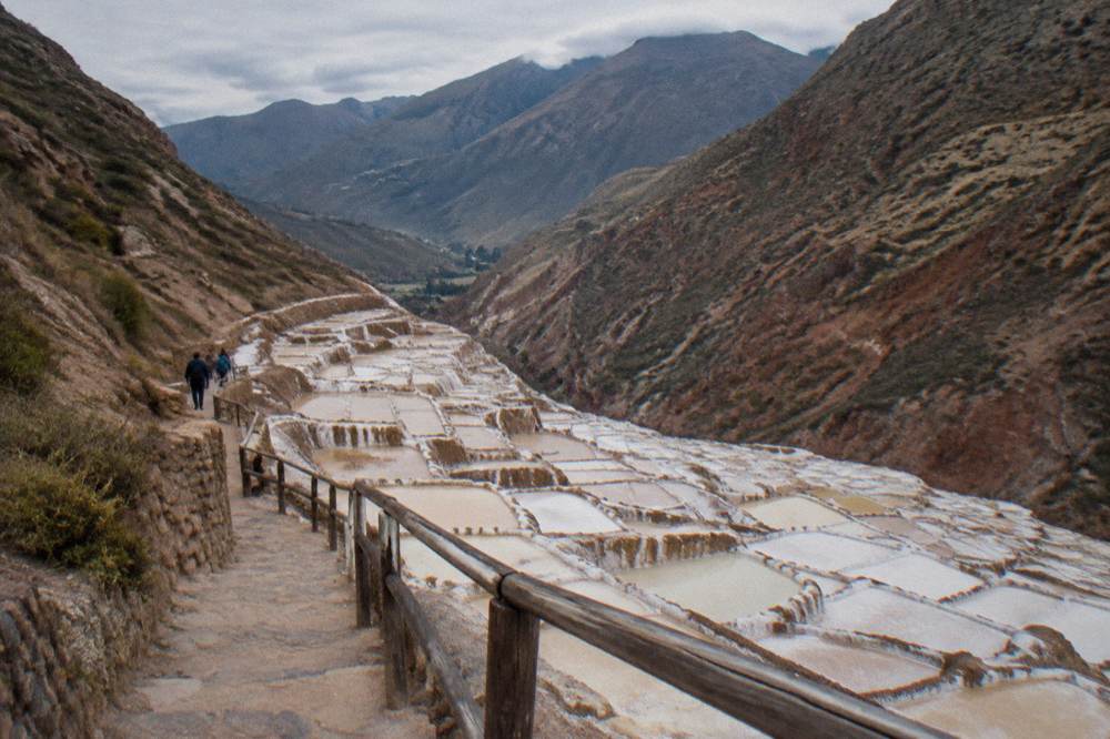 White and ochre salt evaporation ponds terraced down a hillside at Maras