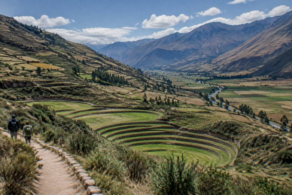 Patchwork fields on the valley floor under scattered clouds along the Urubamba river