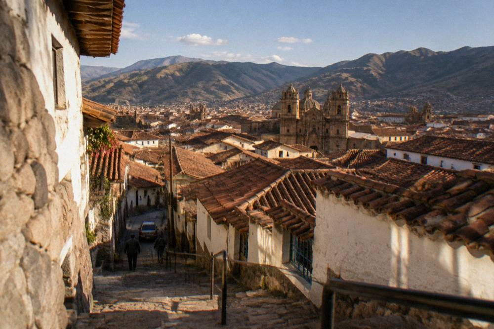 Terracotta rooftops of the Cusco historic centre below a blue sky