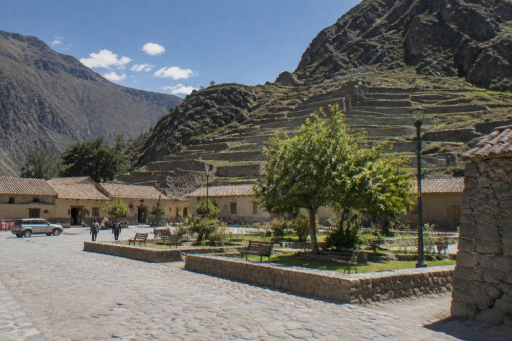 The main square of Ollantaytambo with Inca terraces rising behind it