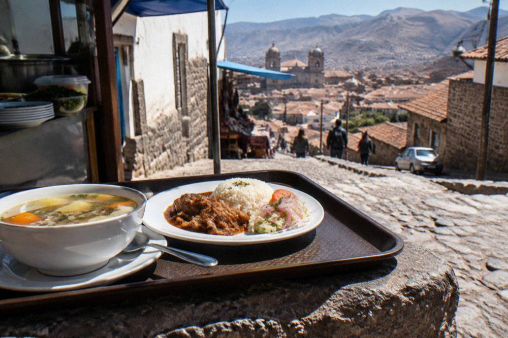 A set lunch of soup and a main course served on a tray at a market counter