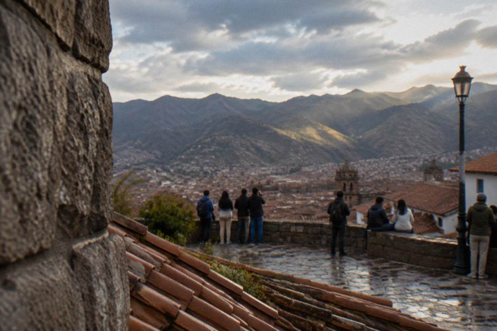 Crowd of visitors on a stone terrace overlooking Andean peaks