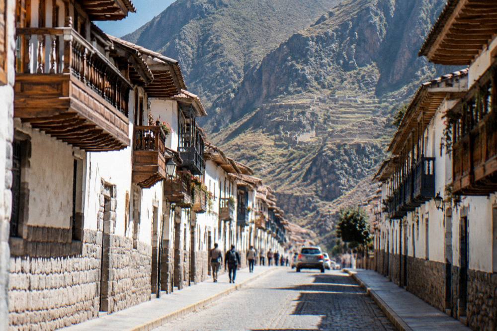 Sunlit pedestrian street in central Cusco with colonial balconies