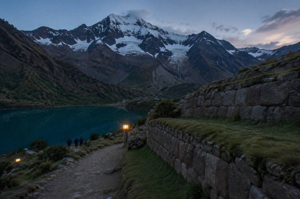 A stone Inca wall with precisely fitted blocks and grass growing between the terraces