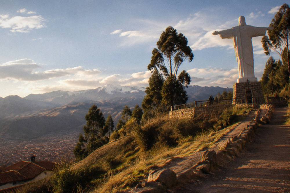 Rolling Andean grasslands above Cusco with eucalyptus trees and distant high peaks