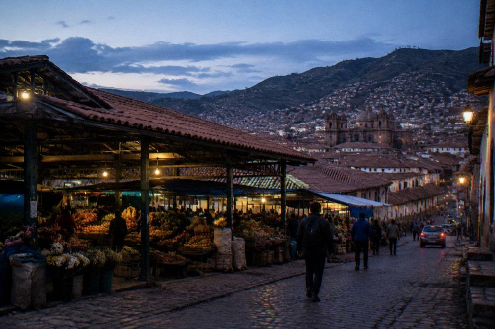 Red-tiled roofs of a high Andean city spreading below green hills