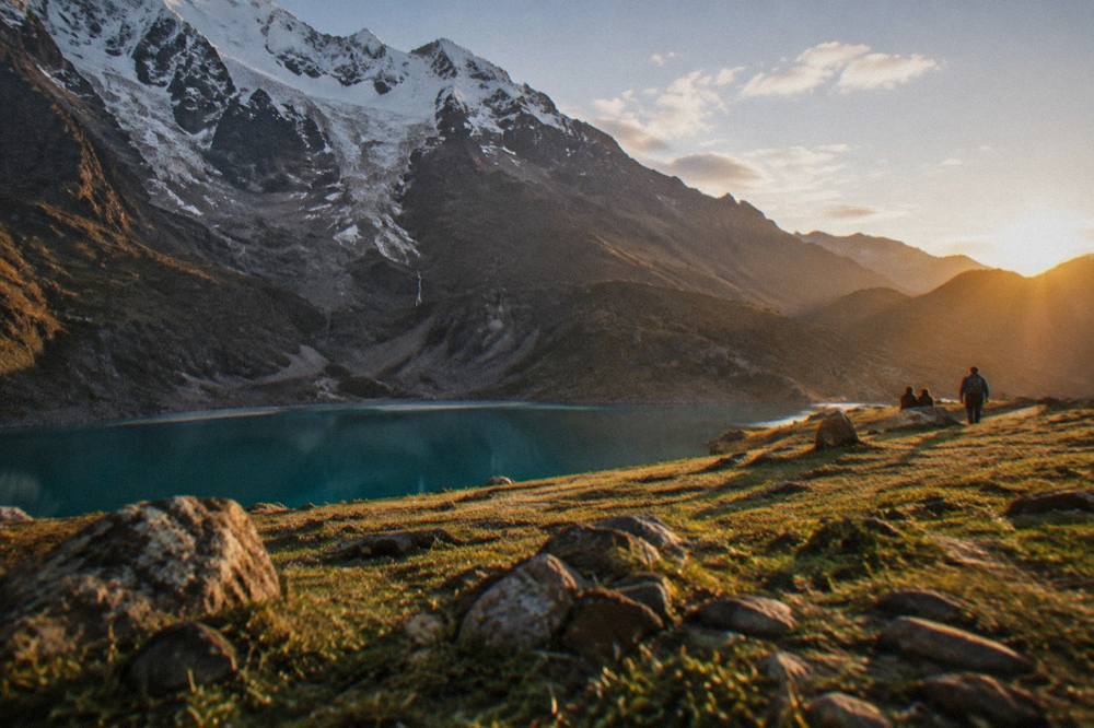 A large open grassy esplanade above a Andean city at sunrise