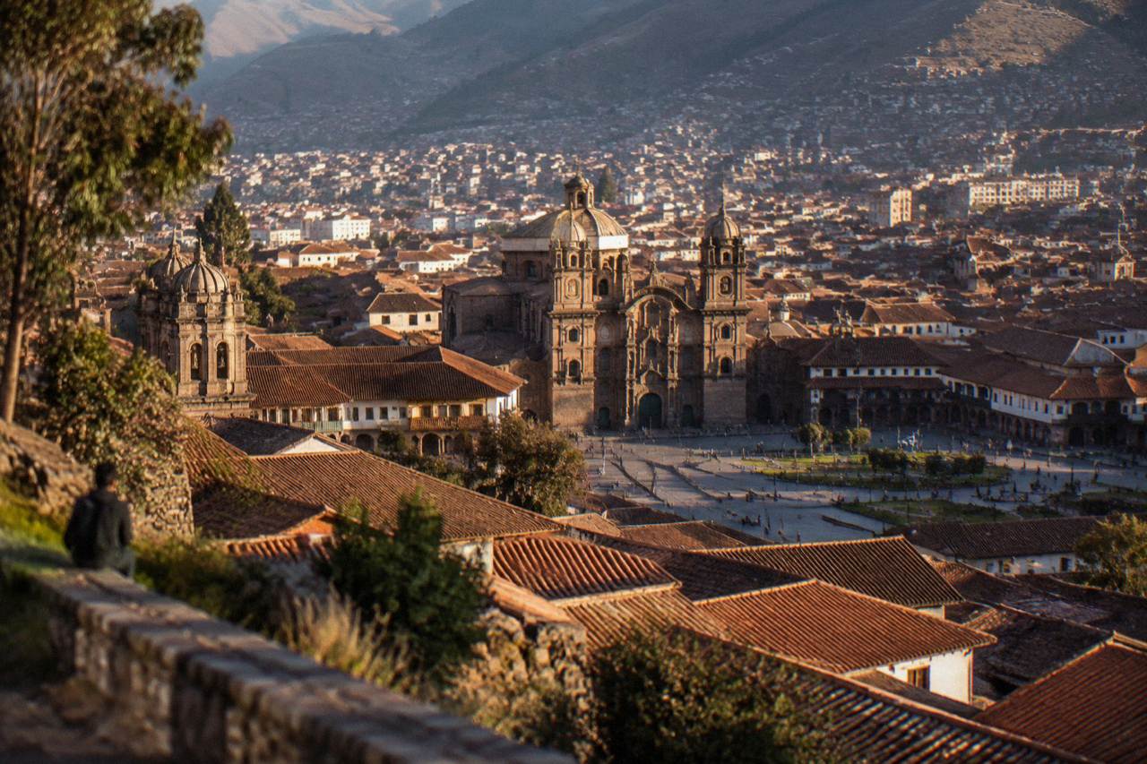 Rooftops and church domes of Cusco seen from a hillside above the city