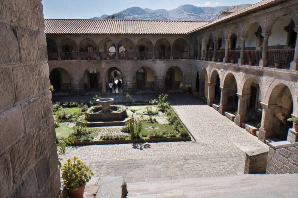 Colonial courtyard of a Cusco museum with stone arches and balconies