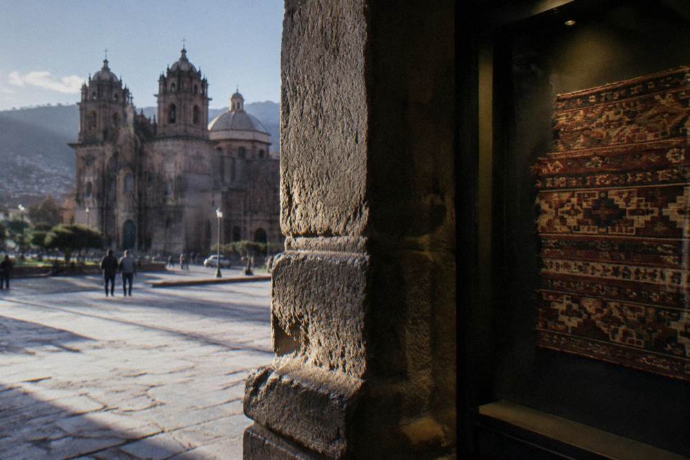 Andean textile fragment displayed in a dimly lit museum case