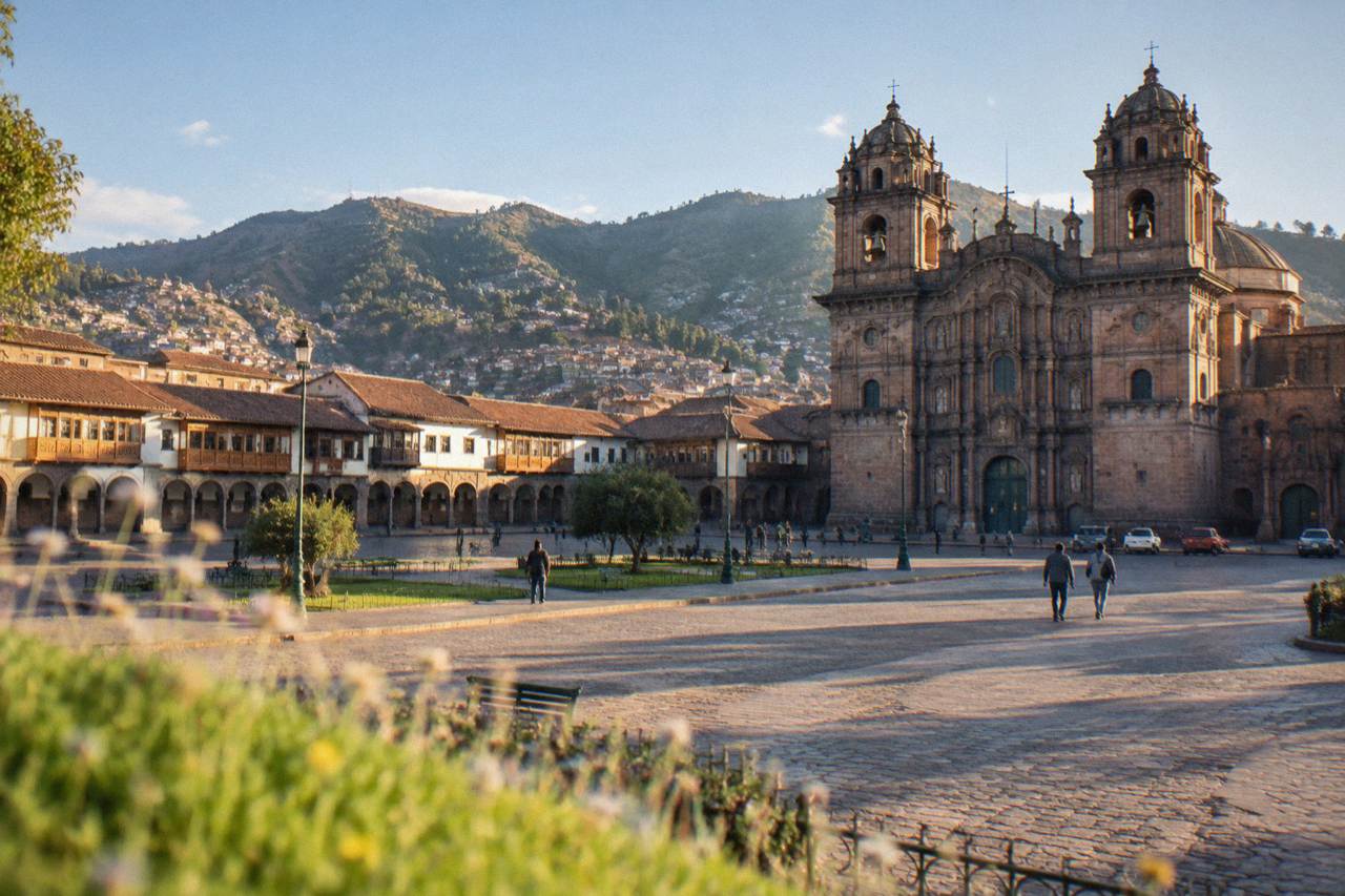 Warm lamplight on stone arcades around the main square of Cusco in the early evening