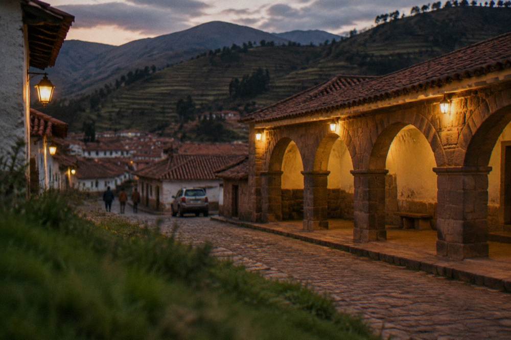 Red tile roofs of a small Andean town with terraced hillsides in evening light