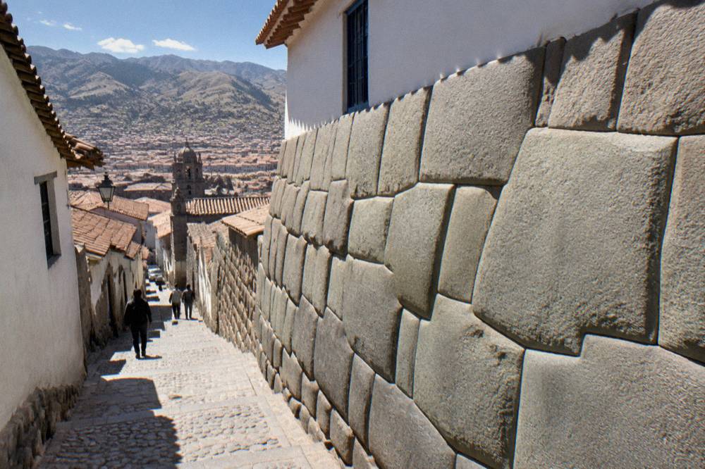 An Inca stone wall on a narrow Cusco street with tightly fitted polygonal masonry