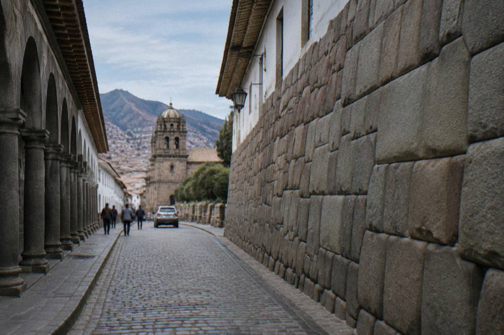 A colonial arcade around a Cusco plaza under a clear sky