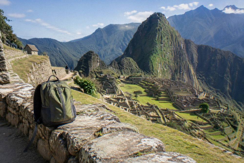 A small daypack on a stone terrace above the Machu Picchu terraces in morning light