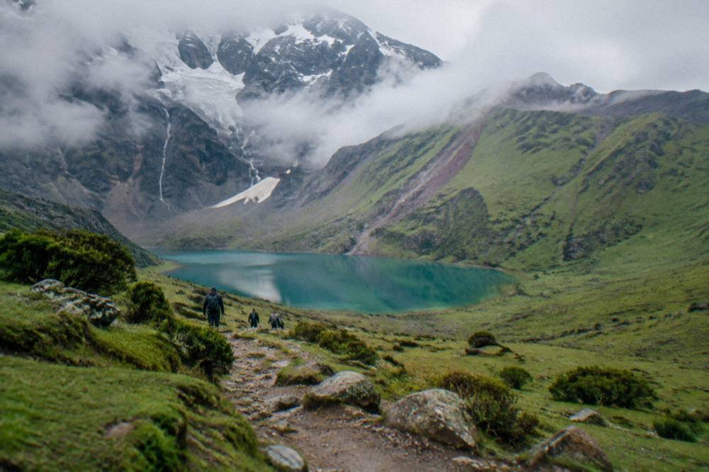 A level high-altitude trail crossing open grassland toward coloured ridges