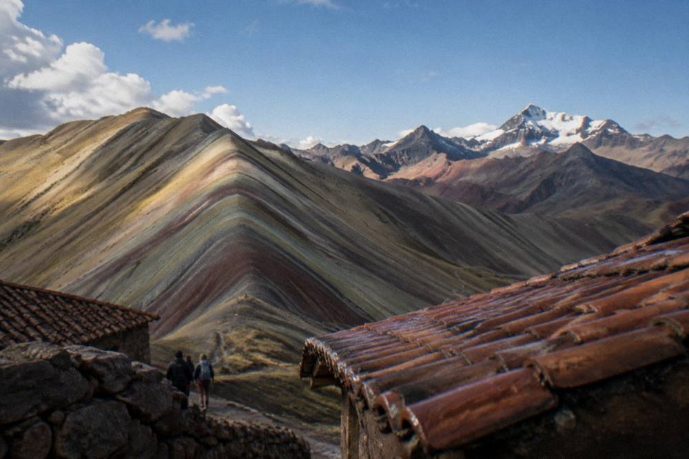 Coloured Andean ridges under a clear blue sky with distant snow peaks